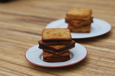 Beyaz bir tabakta, ahşap bir masada duran çikolatalı krakerlerin yakın plan çekimi..