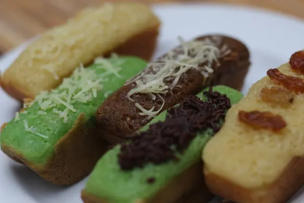 Geleneksel Endonezya kekleri olan çeşitli Kue Pukis 'in yakın plan çekimleri. Peynir, çikolata parçacıkları ve kuru üzüm gibi çeşitli malzemeler..