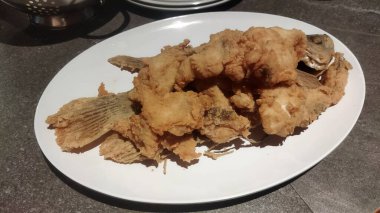 Bir tabak kızarmış balık, lezzetli bir deniz ürünleri tabağı..