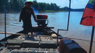Bir adam güneşli bir günde Bengawan 'da tek başına tahta bir tekneye biniyor.