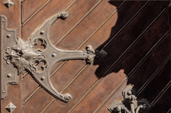 The metal loop on the wooden door of the music hall in Kiev, Ukraine, and the shadow of a head.