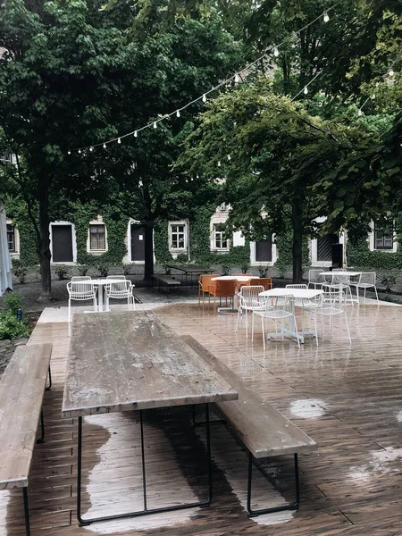 Restaurant terrace under a canopy in a courtyard after the rain.