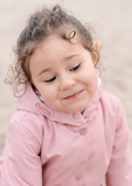 Genç kız sisli bir günde kumlarda oynuyor.