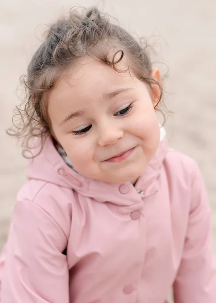 多愁善感的小女孩在雾蒙蒙的日子里在沙滩上玩耍 — 图库照片