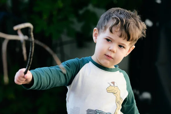 庭で棒で遊んでる男の子 — ストック写真