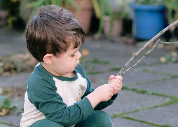 庭で棒で遊んでる男の子 — ストック写真