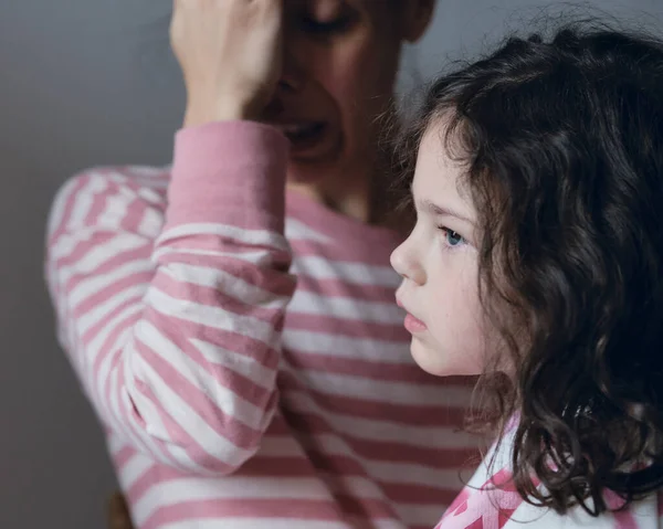 Upset little girl being consoled by mom