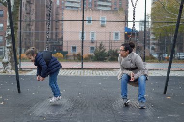 Anne ve kızı salıncakta vakit geçiriyorlar.