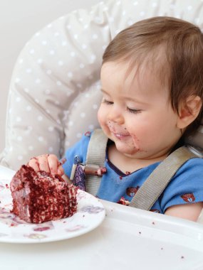 Bu küçük çocuk için ilk doğum günü kutlaması ve ilk kez pasta yemek.