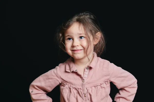 在黑漆漆的背景下在演播室里做表情的可爱女孩 — 图库照片