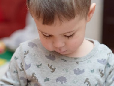 Evde televizyon izlerken oyuncak kamerayla oynayan tatlı çocuk.