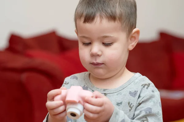 Evde televizyon izlerken oyuncak kamerayla oynayan tatlı çocuk.
