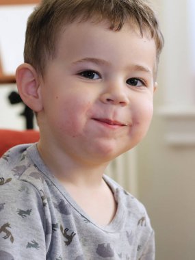 Evde kendini ifade eden genç bir çocuğun portresi.