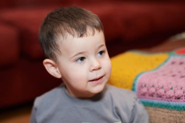 Oturma odasında çizgi film izleyen etkileyici genç çocuk.