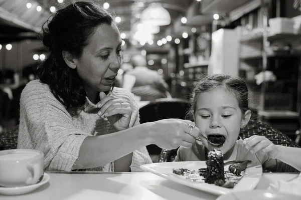 mom and daughter eating desert at a restaurant