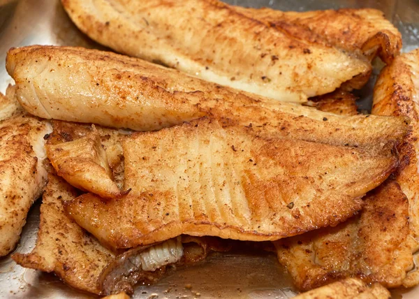 Fırında tilapia fileto, metal bir tavada.