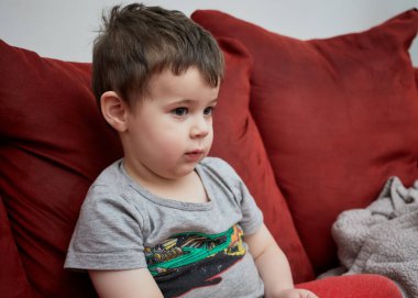 Kanepede surat asan genç bir çocuk.