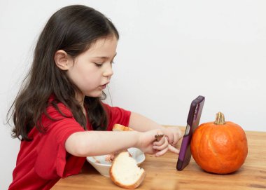 Birincil dişi eksik tatlı bir kız yemek yerken konuşuyor.
