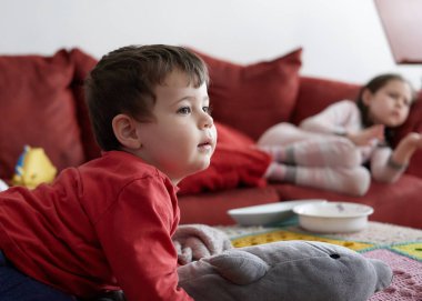 Bekarlar oturma odasında uzanıp televizyon seyrediyorlar.