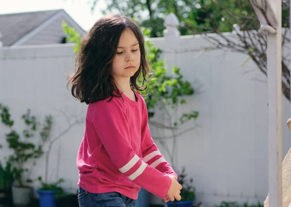 ピンクのシャツを着た可愛い女の子が裏庭でポーズをとって踊る — ストック写真