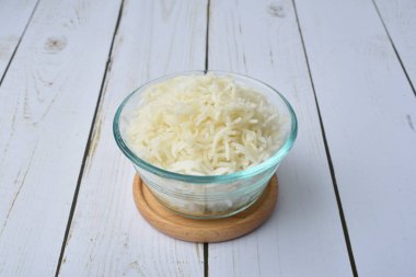 Kırsal bir zeminde cam bir kasede küçük bir porsiyon basmati pilavı.