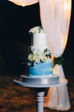 Düğün kemerinin yanında beyaz düğün pastası. Yüksek kalite fotoğraf