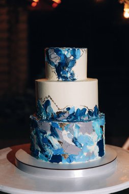 Açık havada yeşillikle süslenmiş küçük güzel bir düğün pastası. Yüksek kalite fotoğraf