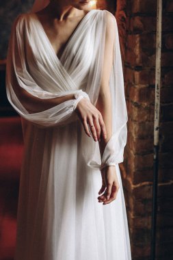 Gelin, kanepede otururken ayakkabısını ayarlıyor, gelin ayakkabılarını giyiyor, kanepede oturuyor. Yüksek kalite fotoğraf. Yüksek kalite fotoğraf