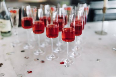 Yumuşak odaklanma. Düğün töreninden önce açık büfe masasında konuklar için Rose şarabıyla kadehler. Şölen masasında kırmızı şampanya olan bir sürü bardak. Kutlama tablosu ayarları.