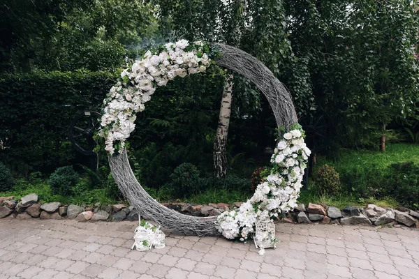 The round wedding arch on the background of the river and greenery. High quality photo. High quality photo