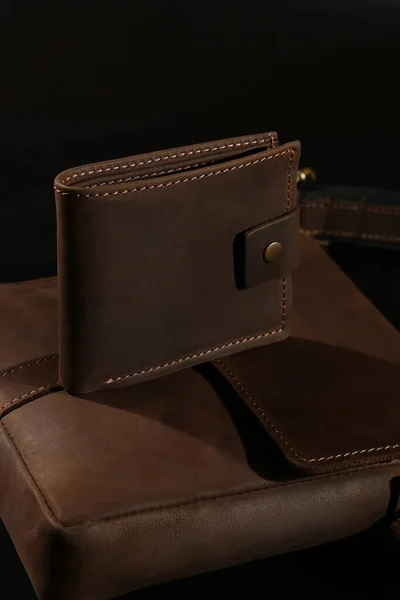 Close Up Classic dark brown leather wallet on black leather background. High quality photo