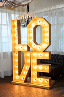 3D resimlere bayılırım. Açık havada düğün resepsiyonunda fotoğraf kabini için ampullerdeki büyük beyaz aşk mektupları. Aşk sözcüğü ışıkları, düğün için şık akşam dekorasyonu.