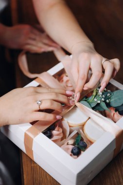 Gri önlüklü bir kız müşteriye siparişi göndermek için içinde krema olan kekleri hediye kutusuna koyar. Yüksek kalite fotoğraf