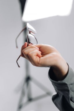 Beyaz arka planda izole edilmiş bir çift gözlüğü tutan erkek el. Yüksek kalite fotoğraf