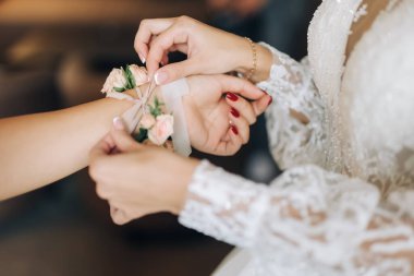 Gelinin gelinliğini giymesine yardım eden kırmızı elbiseli nedimeler, sabah hazırlıkları. Yüksek kalite fotoğraf