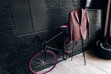Odada siyah tuğla duvar, stil, bisiklet, askıda ceket. Yüksek kalite fotoğraf