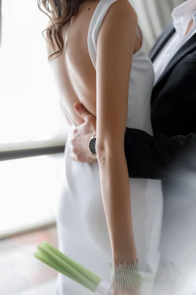 新郎穿着婚纱拥抱新娘的剪影 花束与灰色隔离 高质量的照片 — 图库照片