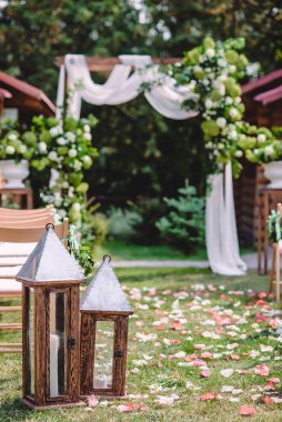 Çiçekler ve beyaz kumaşla süslenmiş düğün kemeriyle açık hava düğün töreni. Yüksek kalite fotoğraf