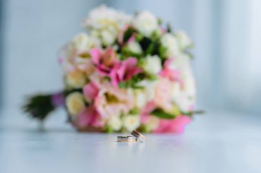 wedding rings lie on a beautiful bouquet as bridal accessories. High quality photo