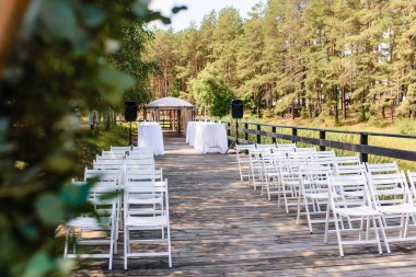 Düğün için beyaz renkli bir yer. Ormanda pastel güller olan beyaz kare düğün kemeri. Yüksek kalite fotoğraf