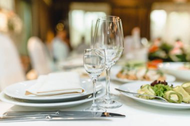 Masadaki restorana boş bardaklar ve beyaz peçeteler yerleştiriliyor. İçinin bir parçası. Yüksek kalite fotoğraf