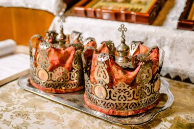 Ortodoks kilisesindeki düğünler için taçlar. Ortodoks kilisesindeki düğünler için taçlar. Kilise düğün vasıfları. Altın kaplama. Kutsal Babamız İncil 'i okuyor. Kilise sunağı. Yüksek kalite fotoğraf