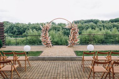 Açık hava düğün töreni için taze çiçeklerle süslenmiş bir düğün kemeri. Modaya uygun bir düğün dekoru. Yüksek kalite fotoğraf