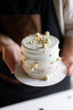 Sihirli bir pasta: Pasta şefi eşsiz bir tasarım yaratmak için ustalıkla dekore ediyor. Yüksek kalite fotoğraf