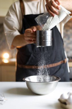Bu fotoğrafta, muhteşem bir pasta yapmak için çalışan bir pasta şefi görüyoruz.. 