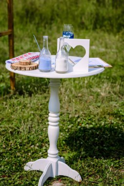 Açık hava düğün yeri - beyaz sandalyeli yeşil çimen tarlası, ahşap şarap fıçısı, siyah mum feneri, güller ve okaliptüs yaprakları dekor. Yüksek kalite fotoğraf