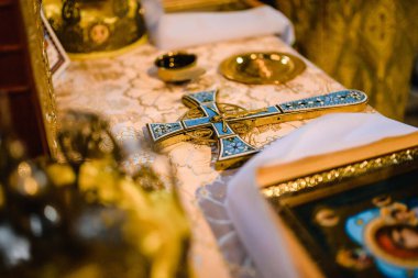 Çocuk ortodoks vaftiz töreni için kutsal kilisede kırmızı ve beyaz kapaklı altın haç. Yüksek kalite fotoğraf. Yüksek kalite fotoğraf