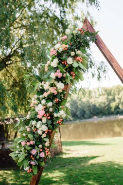 Doğanın ve nehrin arka planında güller olan üçgen kemer. Yüksek kalite fotoğraf