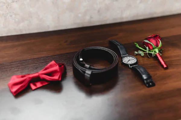 Classic mens accessories - dark blue watch and bow tie on a wooden background prepared for the wedding. High quality photo