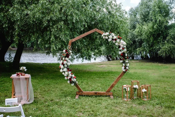 Bröllopsbåge Dekorerad Med Blommor Trästolar Står Grönt Gräs Mot Bakgrunden — Stockfoto